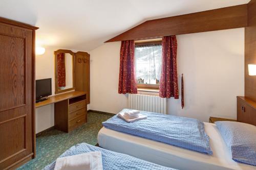 a hotel room with two beds and a television at Casa San Marco n 8 in Livigno