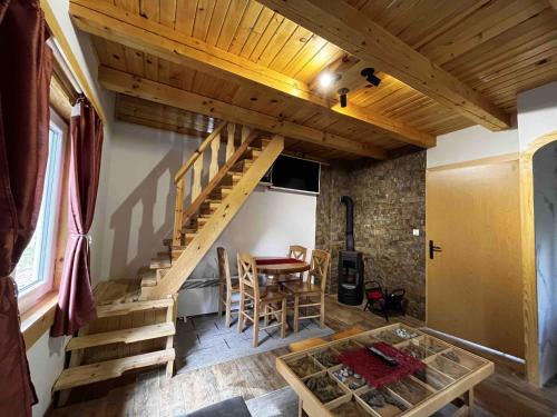 a living room with a wooden staircase and a table at Star Apartments in Bajina Bašta