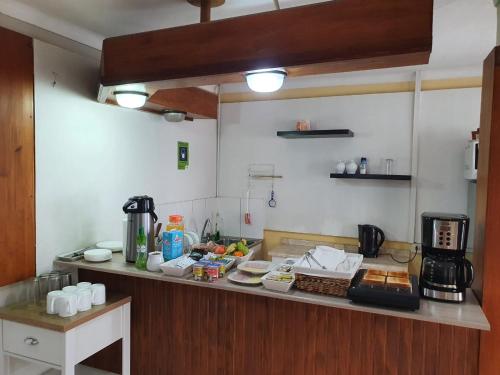 una cocina con una barra con comida. en Hostal del Rio, en Concepción