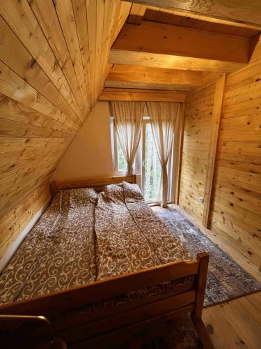 a large bed in a wooden room with a window at Star Apartments in Bajina Bašta