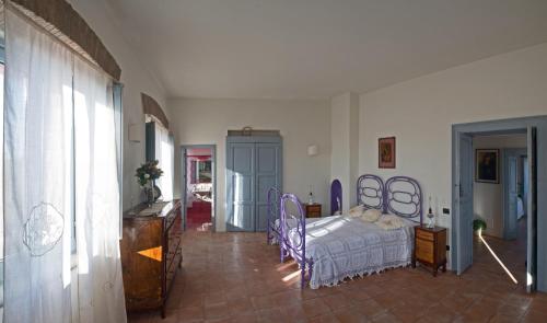 een slaapkamer met een bed met paarse stoelen erin bij Agriturismo Piano del Monaco in Marcellinara