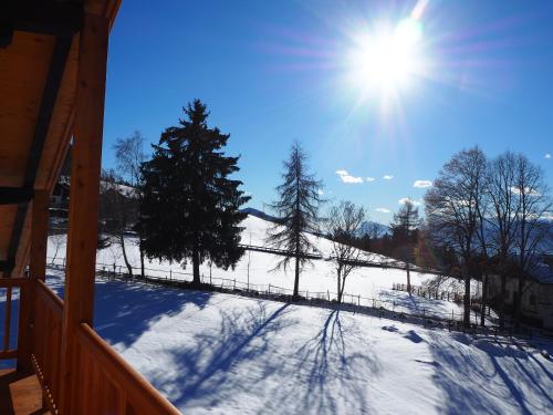 a snow covered porch with the sun in the sky at Ebner Appartements in Aldino