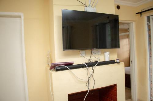 a flat screen tv on a wall above a fireplace at Zoe Homes 1br and 2br Cottage own compound -Kericho town near Green Square mall in Kericho