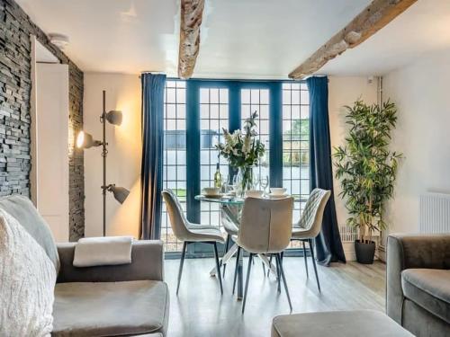 a living room with a table and chairs at 2 bedroom cosy cottage with hot tub in hambrook close to Bristol City Centre in Bristol