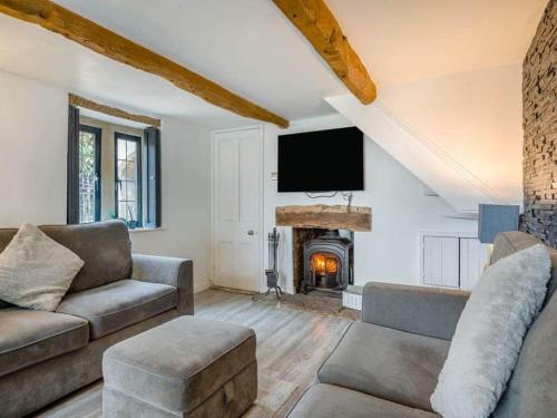 a living room with a couch and a fireplace at 2 bedroom cosy cottage with hot tub in hambrook close to Bristol City Centre in Bristol