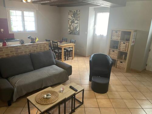 ein Wohnzimmer mit einem Sofa und einem Tisch in der Unterkunft Gite "La Gaudoiterie" in Saint-Martin-du-Fouilloux