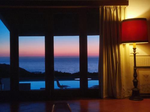 a room with a window with a view of the ocean at Herdade AMÁLIA RODRIGUES in Zambujeira do Mar