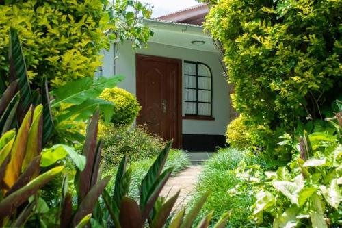 a garden with a pathway leading to a small house at Zoe Homes 3br Mansionette Own Compound Kericho town near Green Square mall in Kericho