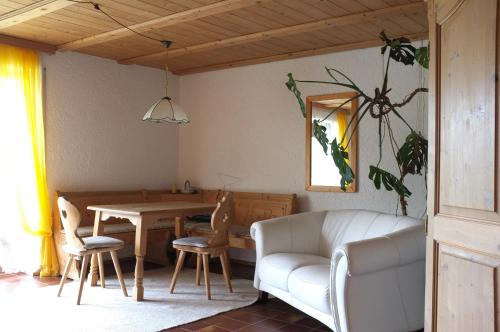 - un salon avec une table, des chaises et un canapé dans l'établissement Pension Steiger, à Bad Griesbach im Rottal