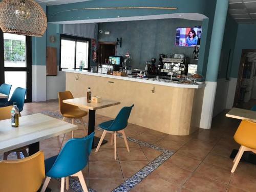 a restaurant with tables and chairs and a bar at Hotel Macavi Playa in Rota