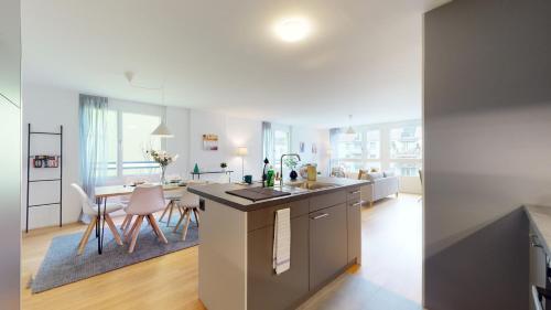 a kitchen and living room with a table and chairs at Sublime contemporary apartment in the city centre in La Chaux-de-Fonds