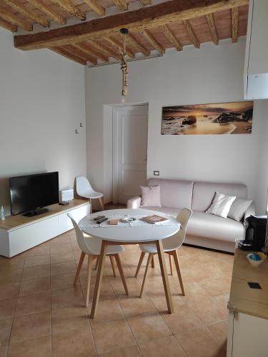 un soggiorno con un tavolo e un divano di Serendipity House a Grosseto