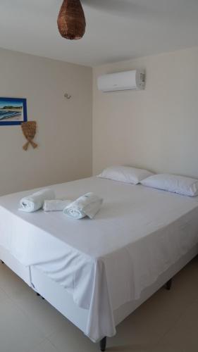 a white bed with white sheets and towels on it at Espetacular Casa de Charme em São Miguel do Gostoso - Salou in São Miguel do Gostoso