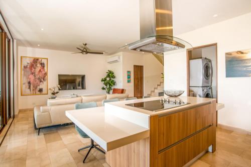a kitchen and living room with a kitchen island and a couch at Aromo TH3 Townhouse with private pool Reserva Conchal in Playa Conchal