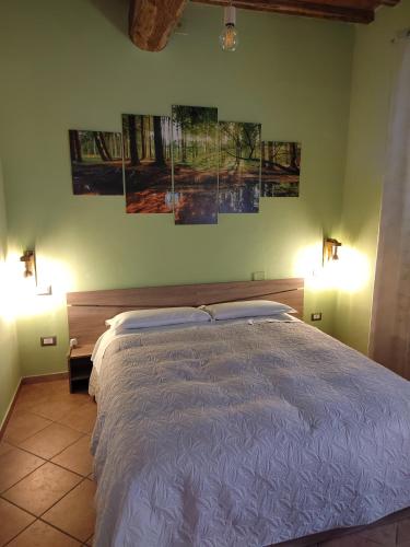 a bedroom with a bed with three paintings on the wall at Serendipity House in Grosseto