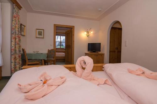 a bedroom with two beds with pink towels on them at Schiederhof in Mittersill
