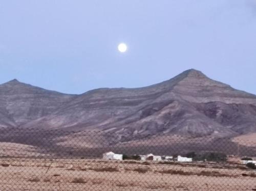 a mountain in the middle of a desert with a fence at La Hacienda de Tefia in Tefía