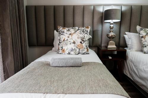 a bedroom with a bed with a pillow on it at Villa Gracia Guesthouse in Klerksdorp