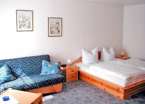 uma sala de estar com uma cama e um sofá em Hotel-Restaurant Zum Dorfkrug em Winterberg