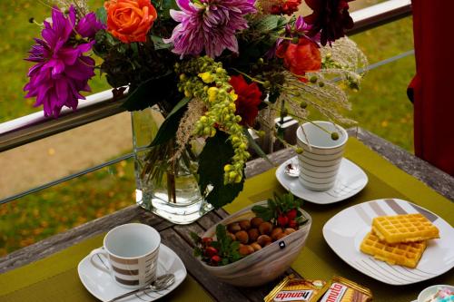 a table with a vase of flowers and a vase of food at Parkresidenz Lychen, Ferienwohnung 5 in Lychen