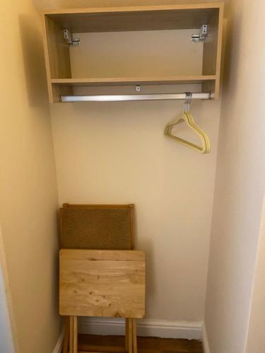 a closet with a wooden chair and a hanger at Clarendon Lodge - accommodation only in Skegness