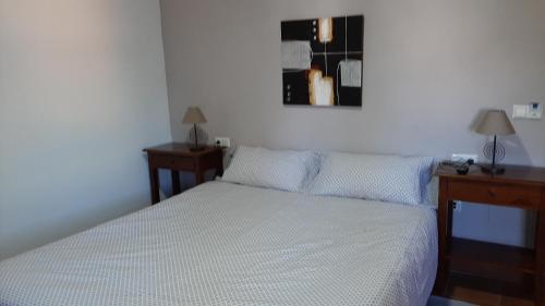 a bedroom with a white bed with two night stands and two tables at Ronda in Ronda