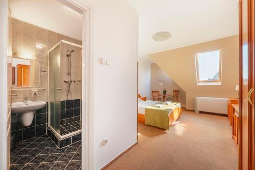 a bathroom with a sink and a bed in a room at Baross City Hotel - Budapest in Budapest