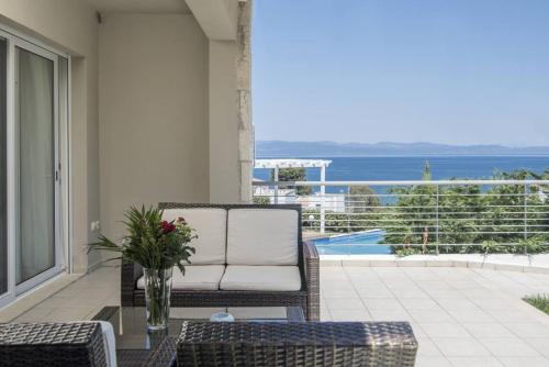a wicker chair on a balcony with a view of the ocean at Kappa Resort in Paliouri