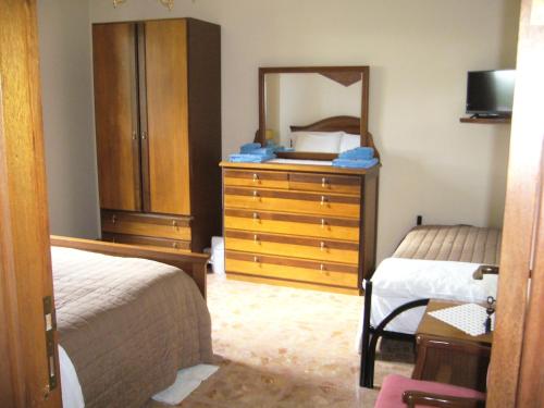 a bedroom with two beds and a dresser and a mirror at Casa Berti in Spello