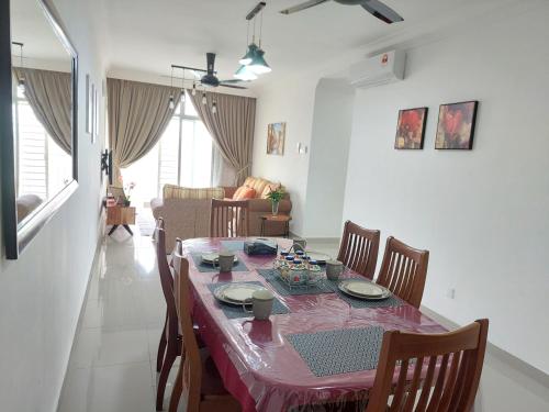 Dlake Putrajaya Homestay في بوتراجايا: طاولة طعام مع طاولة قماش وردية وكراسي
