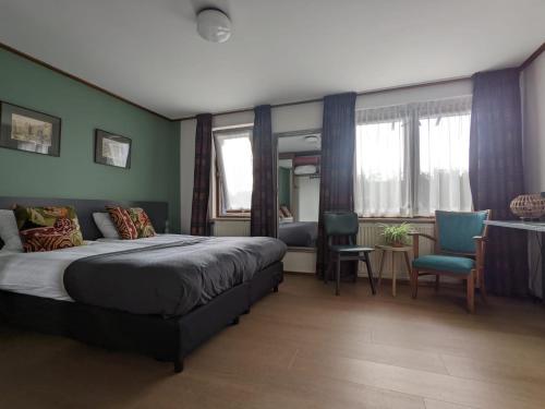 a bedroom with a bed and a table and chairs at Hotel De Gravin van Vorden in Vorden