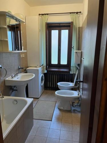a bathroom with a sink and a toilet and a window at Condominio Dorf in Sappada