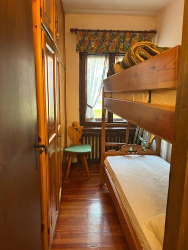 a small room with a bunk bed and a window at Condominio Dorf in Sappada