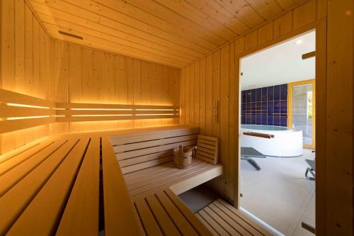 uma sauna com um banco numa sala de madeira em Chalet L'Urson, spacieux, jacuzzi, hammam et sauna em Gérardmer