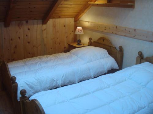 - 2 lits dans une chambre dotée de murs en bois dans l'établissement Duplex cosy pour 4 pers avec jardin, exposé sud, centre Valloire, proche télécabine et loisirs - FR-1-263-227, à Valloire