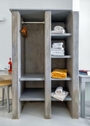 a cupboard in a kitchen with towels on the shelves at Coralli Seaside Resort in Livadakia
