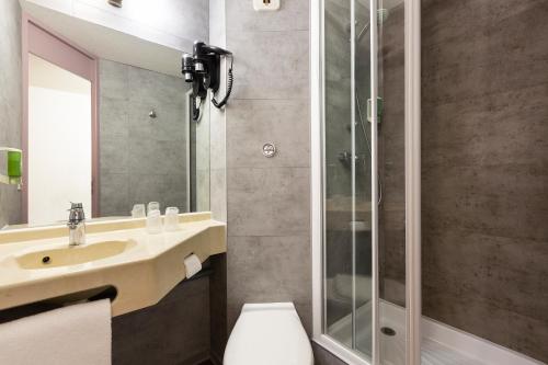 a bathroom with a sink and a shower and a toilet at B&B HOTEL Marne-la-Vallée Chelles in Chelles