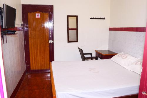 a room with a bed and a table and a chair at PARI MUTHU VILAS in Chidambaram