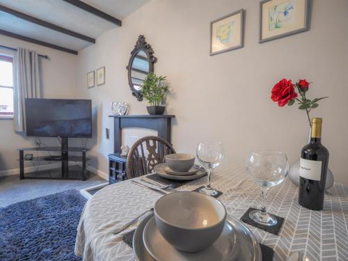 a dining room with a table with a bottle of wine at Trenewydd Farm Holiday Cottages in Cardigan