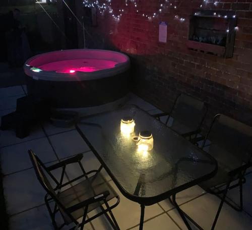 a table and chairs with a hot tub in a room at The Lodge - Dog Friendly Farm Cottage in Norwich