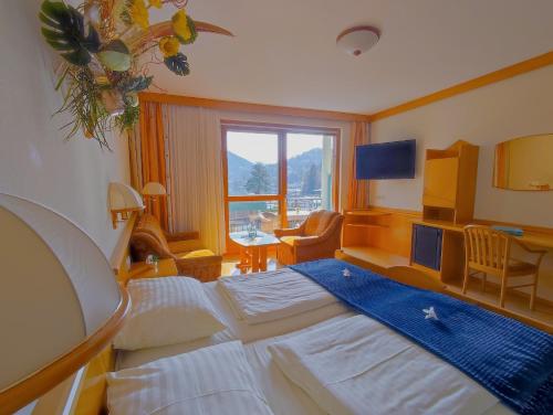 a hotel room with a large bed and a window at Seehotel Princes in Sankt Kanzian