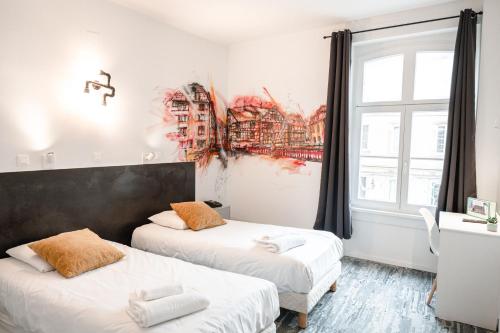 a bedroom with two beds and a window with a painting at Hotel des Arts - Centre Cath&eacute;drale in Strasbourg