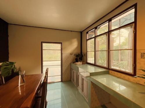 eine Küche mit zwei Waschbecken und zwei Fenstern in der Unterkunft วังภูไพร ฟาร์มสเตย์ in Wang Nam Khieo