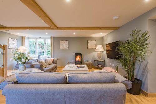 a living room with two couches and a fireplace at The Dairy by Bloom Stays in Ulcombe