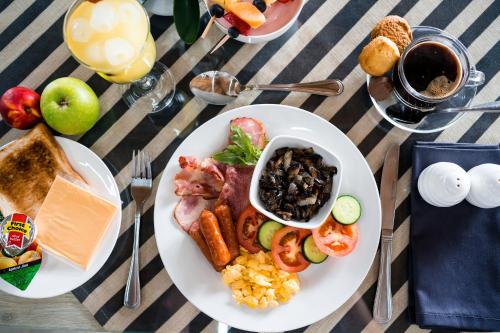 a table with a plate of breakfast food on it at Villa Gracia Guesthouse in Klerksdorp