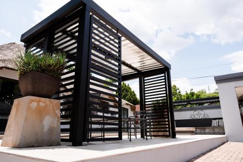 a small house with a black roof at Villa Gracia Guesthouse in Klerksdorp