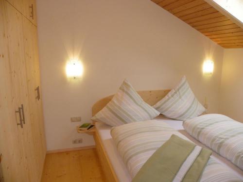 ein Schlafzimmer mit einem Bett mit zwei Kissen darauf in der Unterkunft Ferienwohnung Zwiesel in Wackersberg