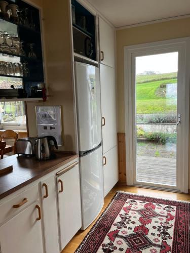 a kitchen with a white refrigerator and a window at Villa med fantastisk utsikt in Båstad
