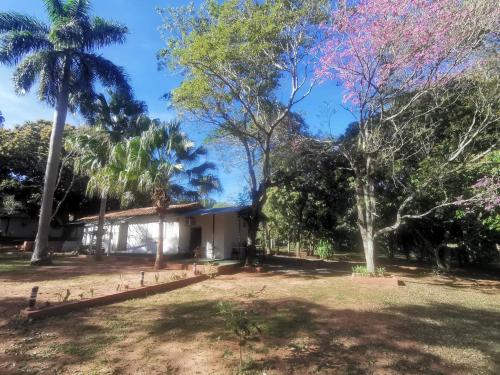 a house in the middle of a yard with trees at El Paraje Camping in Piribebuy