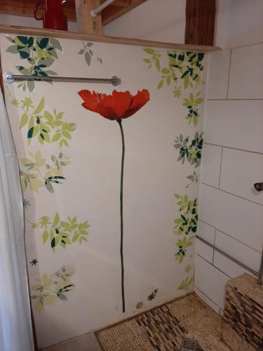 a red flower painted on the wall of a bathroom at Landhaus Gschmeidler in Selzthal